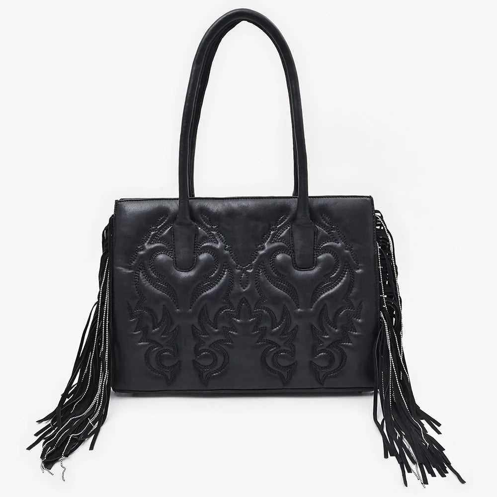 Black handbag with intricate design and fringes on a white background