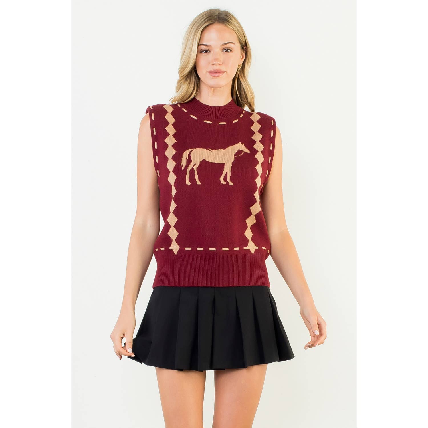 Woman wearing a red sleeveless sweater with a horse design on a white background