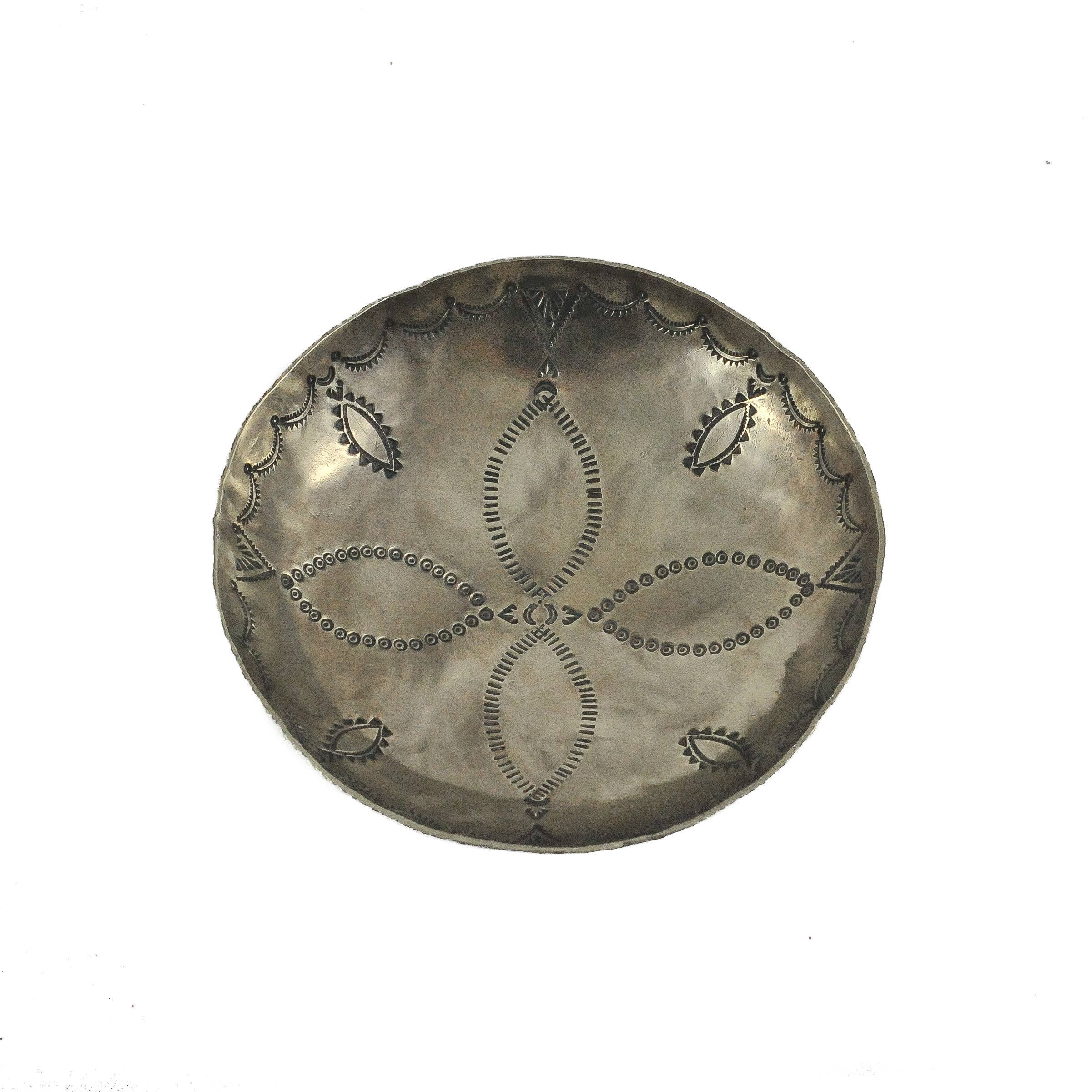 Decorative silver plate with intricate patterns on a white background