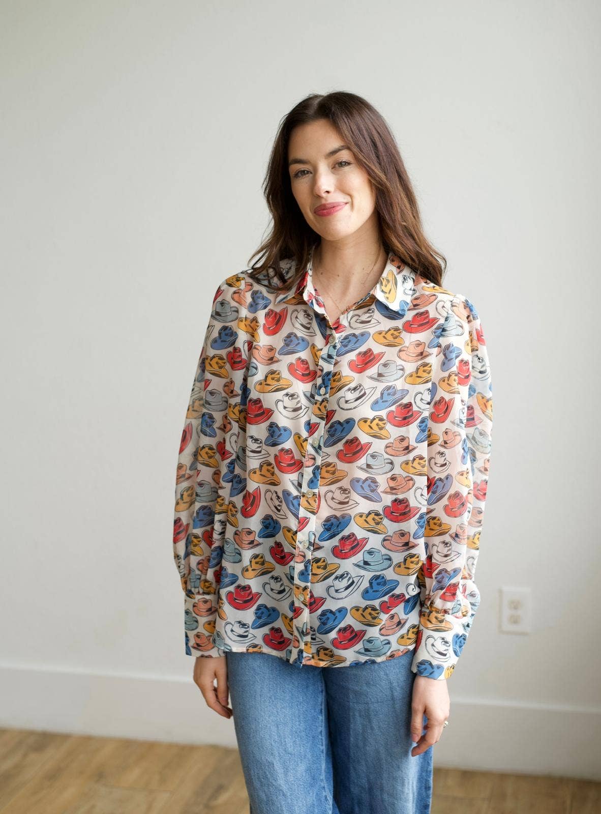 Woman wearing a colorful patterned shirt with a plain background