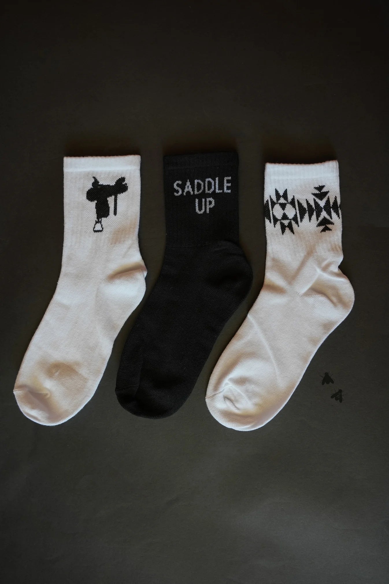 Western Vibe Socks Set featuring three unique designs: a saddle silhouette, "Saddle Up" text, and a geometric Western pattern. One size fits most.