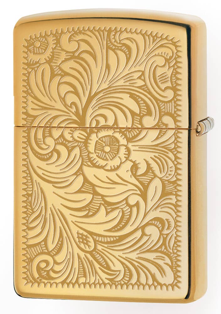 Gold lighter with intricate floral design on a white background