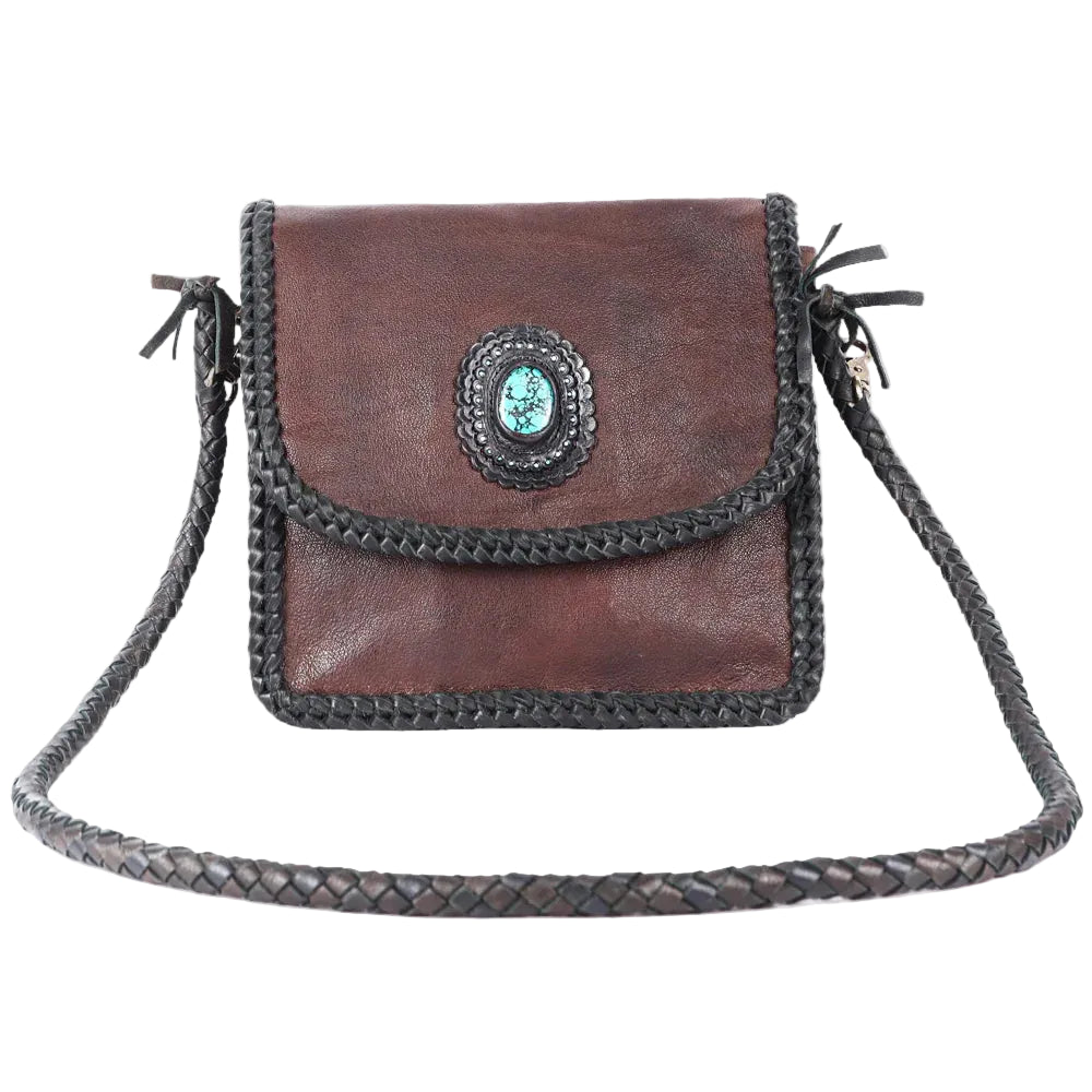 Brown leather handbag with braided strap on a white background