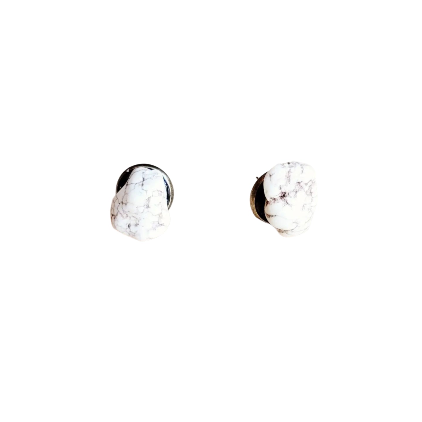 A pair of white and brown marbled stone stud earrings with an antique metal backing, displayed on a light wooden surface. Each stone has a unique shape, highlighting a rustic and natural aesthetic