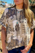 Roughstock Rodeo Tee – Western cowboy graphic t-shirt featuring a vintage rodeo print with bronc riders and desert scenery. Relaxed fit with soft polyester-spandex fabric, perfect for western style enthusiasts.