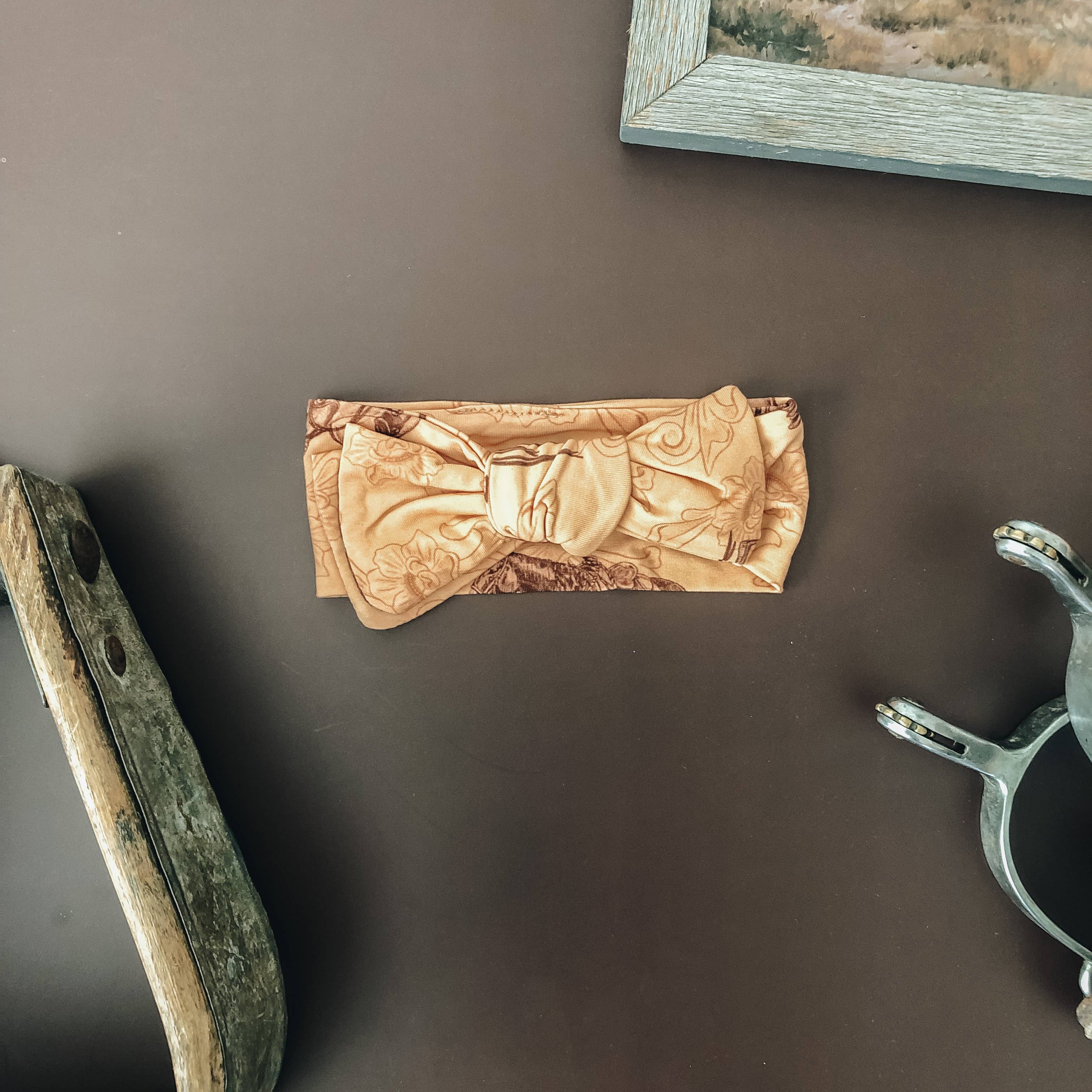 Infant bamboo bow headband in burnt orange with western horse sketch print, soft stretch fabric sized 0-3 month