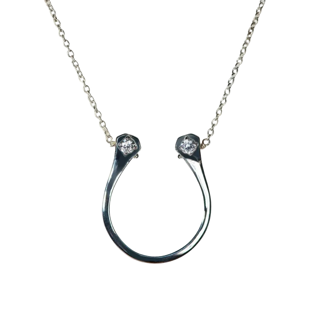 Silver horseshoe necklace with two small diamonds on a light gray background