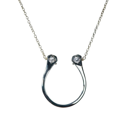 Silver horseshoe necklace with two small diamonds on a light gray background