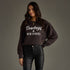 Woman wearing a dark brown sweatshirt with &