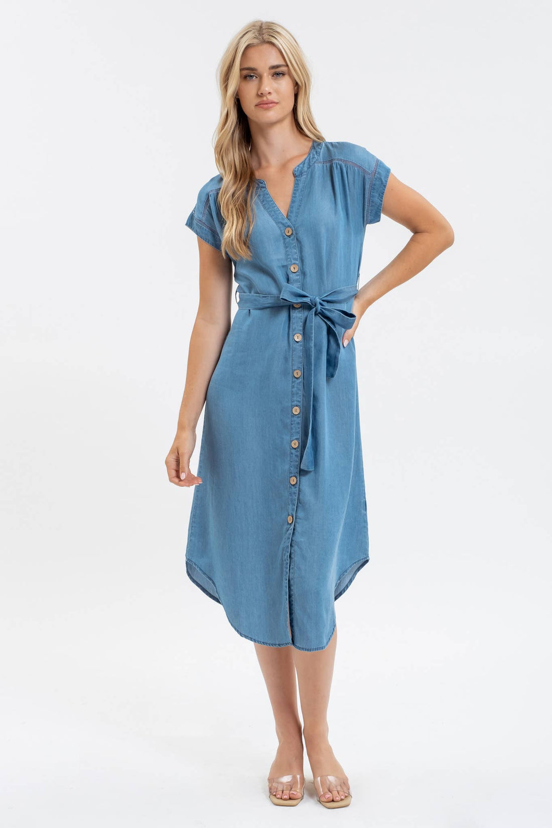 Woman wearing a blue dress with buttons on a white background