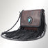 Brown leather handbag with fringe and a decorative emblem on a light gray background
