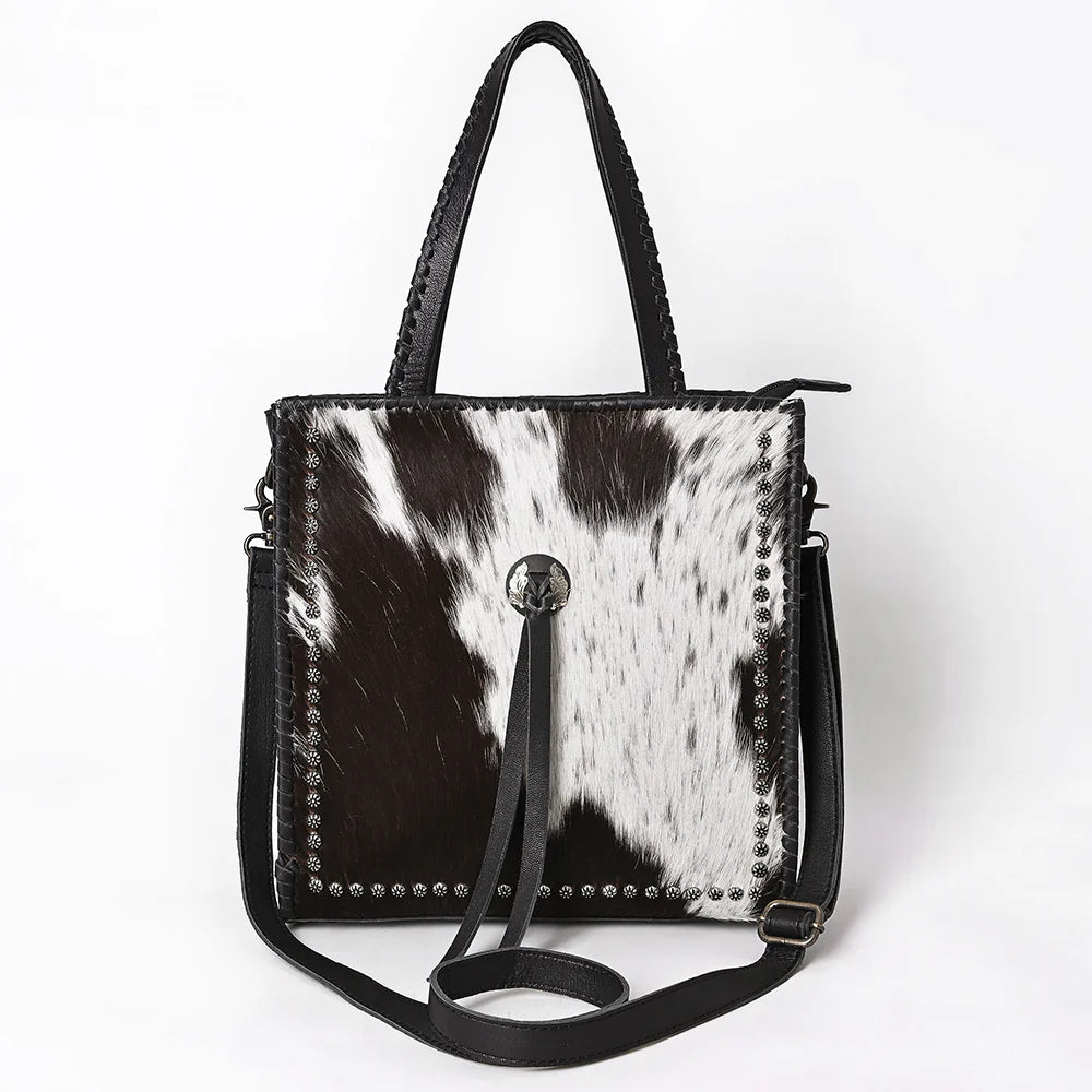 Handbag with black and white cowhide pattern on a white background