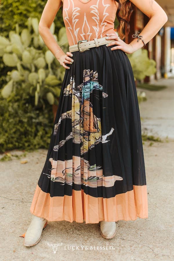 Person wearing a patterned dress with a black and peach skirt, standing outdoors.