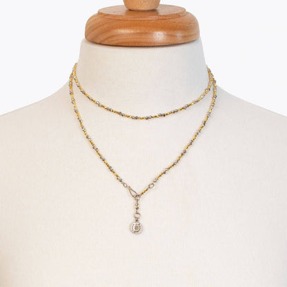 Gold necklace on a mannequin with a white background