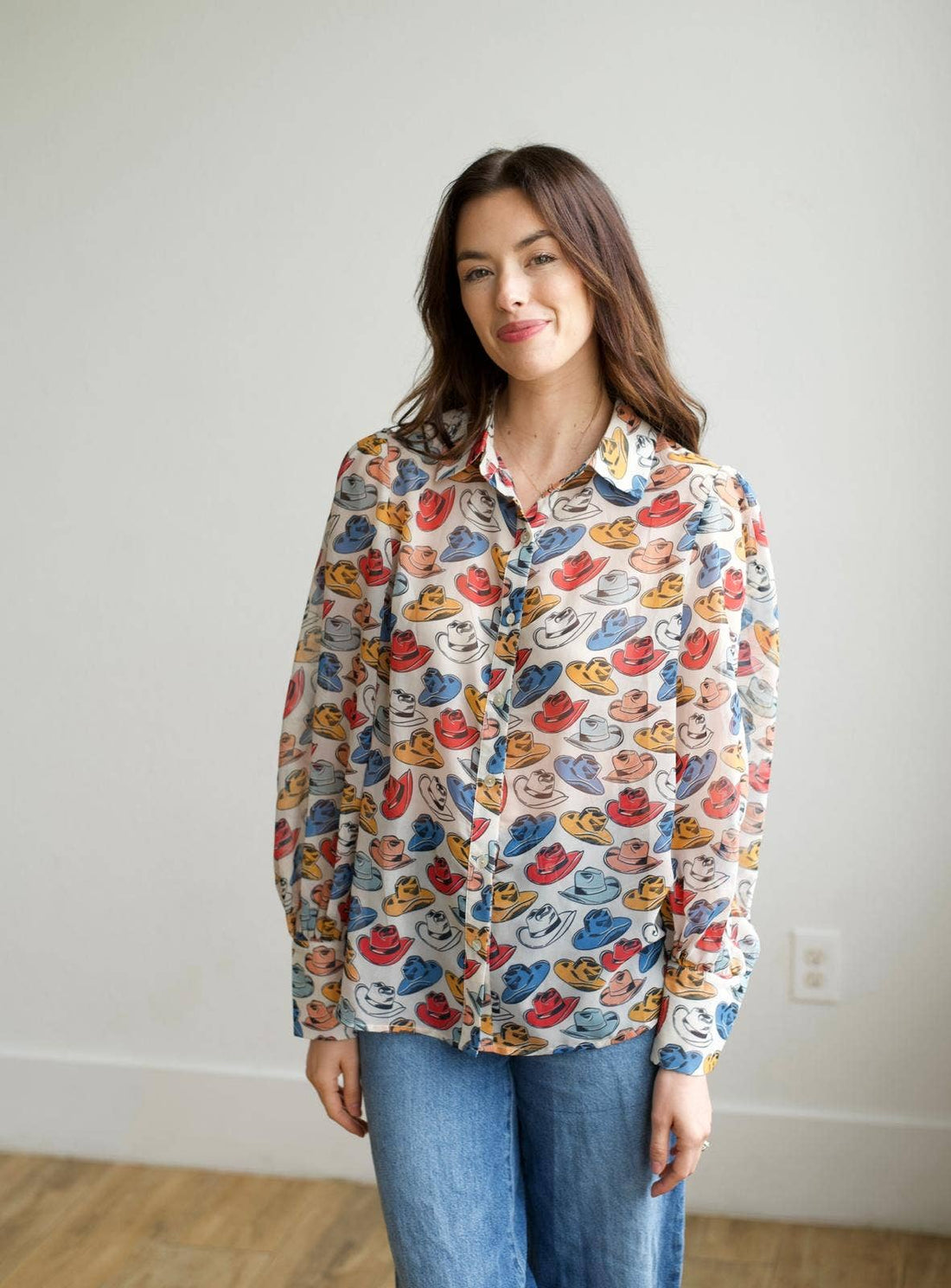 Woman wearing a colorful patterned shirt with a plain background