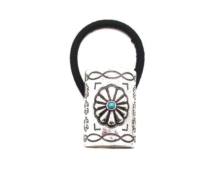 Decorative hair tie with a silver and turquoise design on a white background