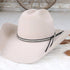 Beige cowboy hat with a black band on a wooden surface