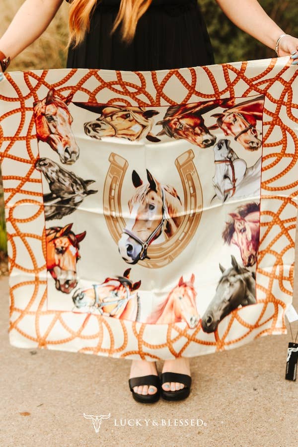 Person holding a scarf with horse and horseshoe pattern, brand &