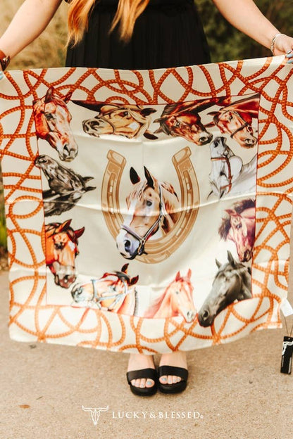 Person holding a scarf with horse and horseshoe pattern, brand &