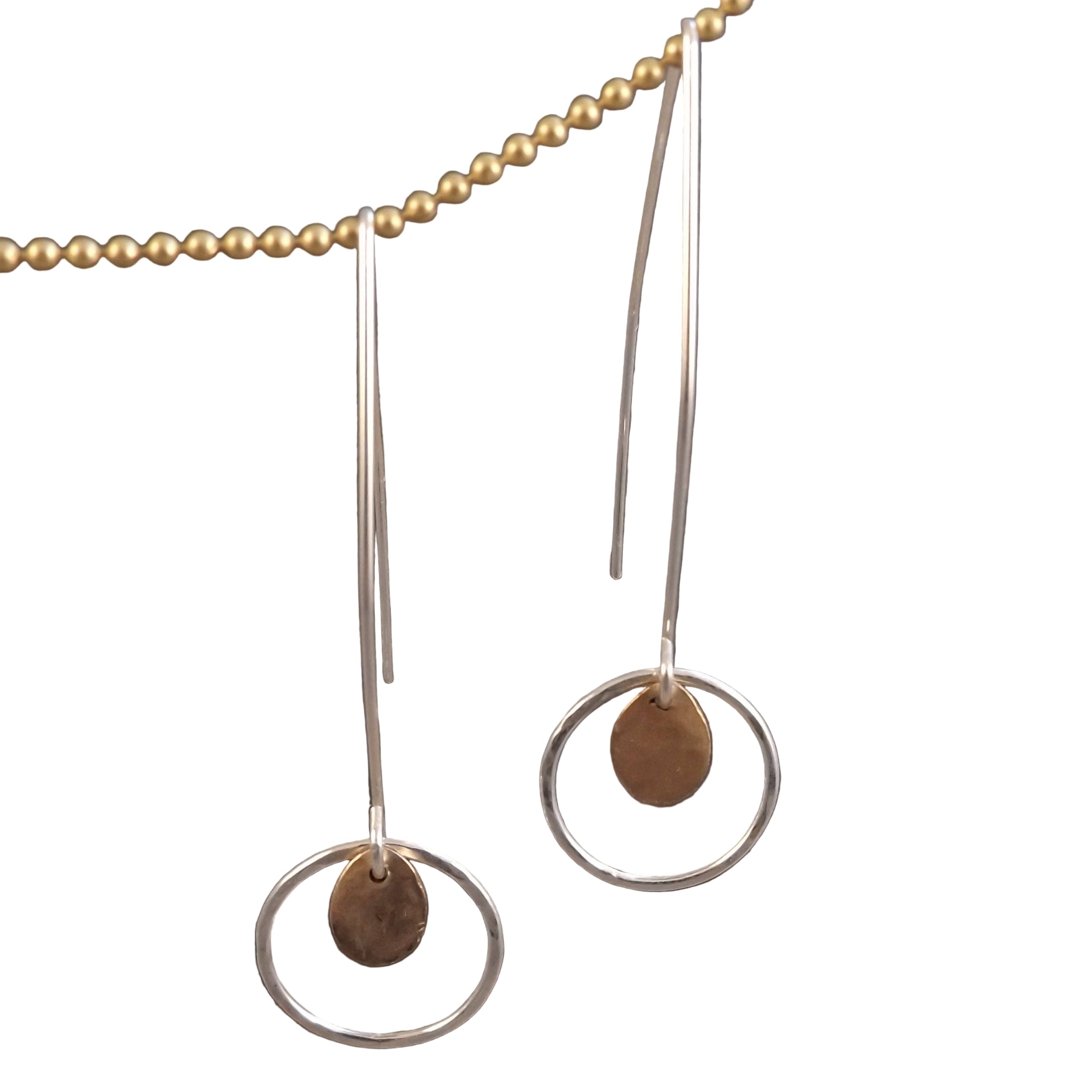 Pair of earrings with circular designs and gold beads on a white background