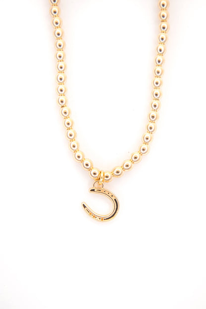 Gold necklace with a crescent moon pendant on a white background