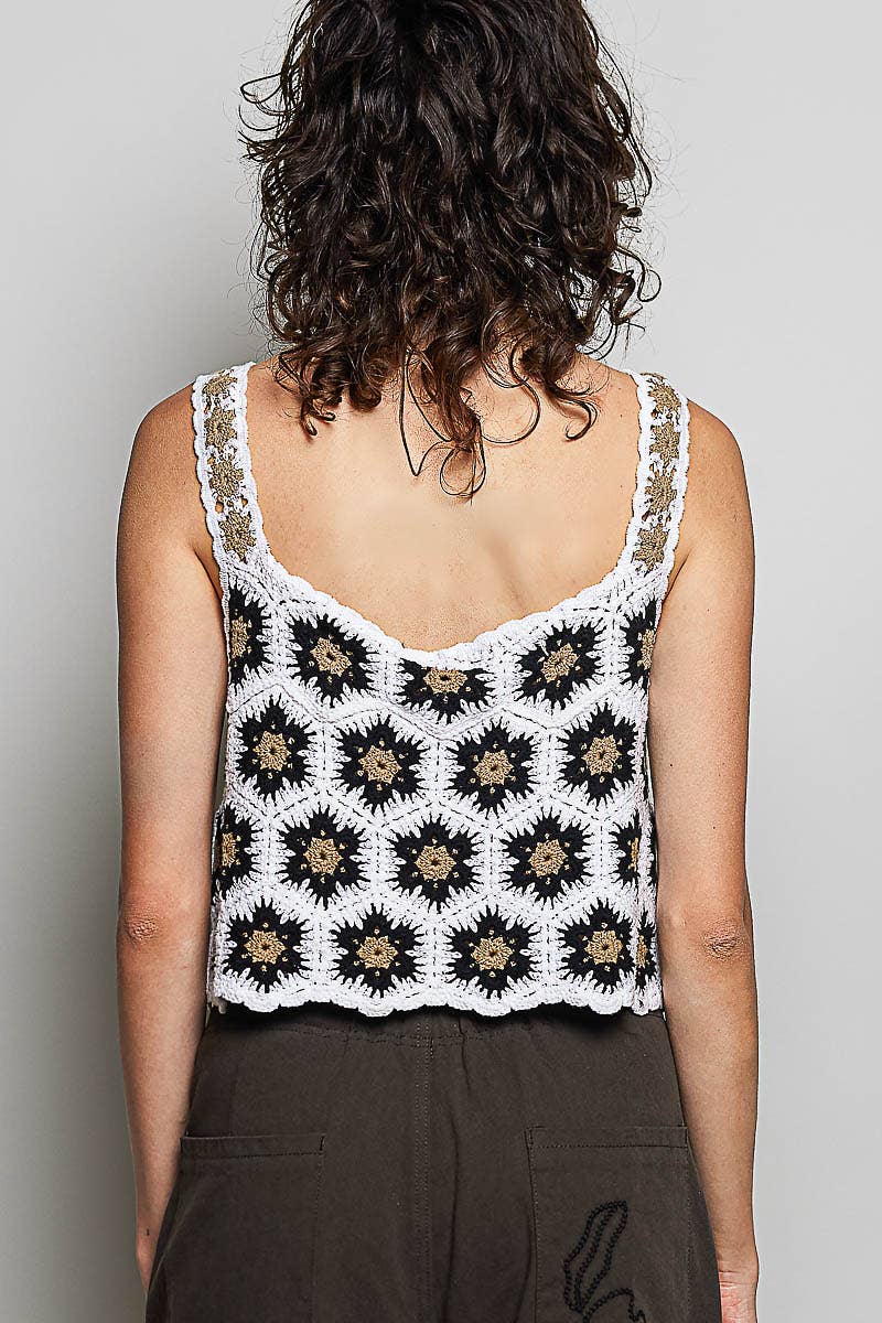Model wearing the High Desert Crochet Tank, a handcrafted crochet crop top featuring a square neckline, wide floral-weave straps, scalloped edges, and a black, ivory, and camel granny square pattern, paired with an embroidered brown skirt.