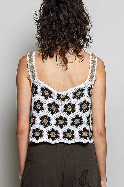 Model wearing the High Desert Crochet Tank, a handcrafted crochet crop top featuring a square neckline, wide floral-weave straps, scalloped edges, and a black, ivory, and camel granny square pattern, paired with an embroidered brown skirt.