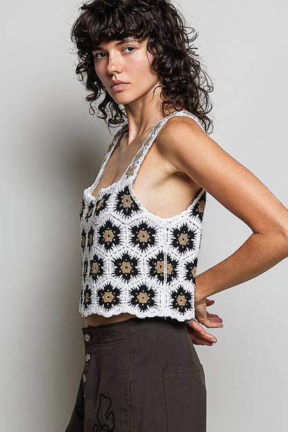 Model wearing the High Desert Crochet Tank, a handcrafted crochet crop top featuring a square neckline, wide floral-weave straps, scalloped edges, and a black, ivory, and camel granny square pattern, paired with an embroidered brown skirt.