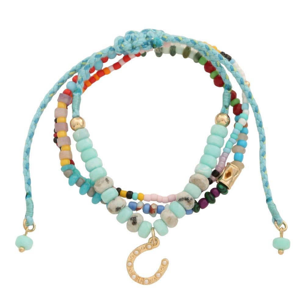 Colorful beaded bracelet with horseshoe charm on a white background
