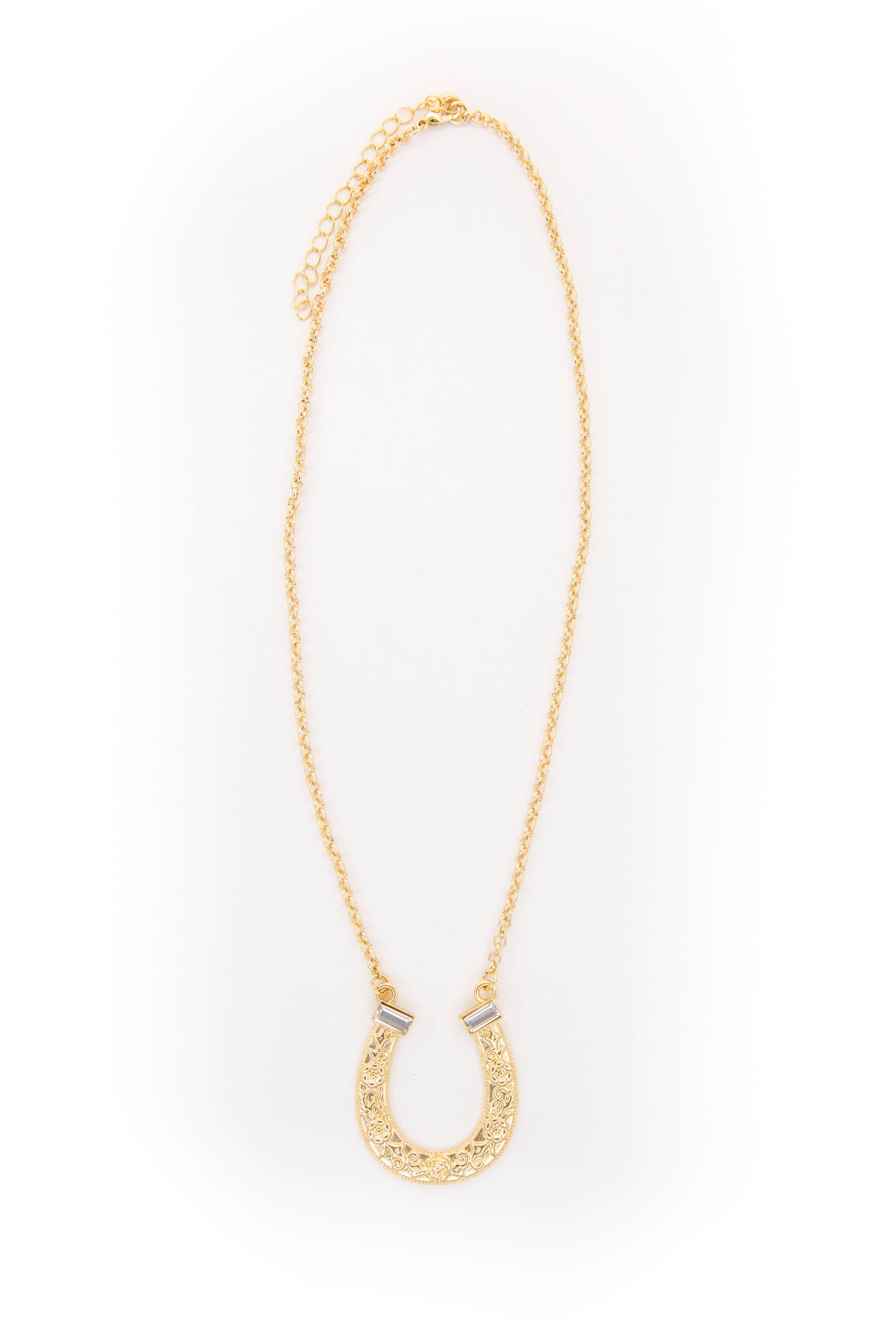 Gold necklace with a horseshoe pendant on a white background