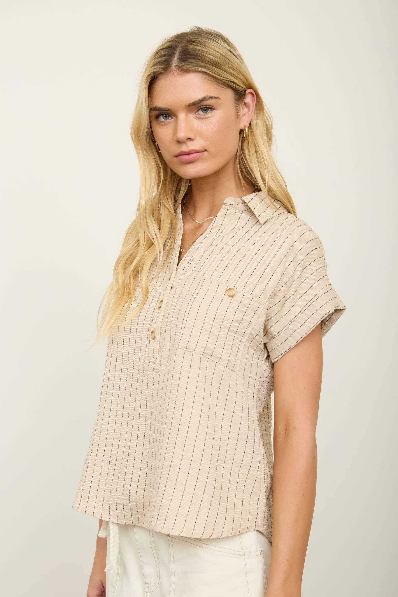 Neutral striped collared blouse with short cuff sleeves, half button front, and chest pocket
