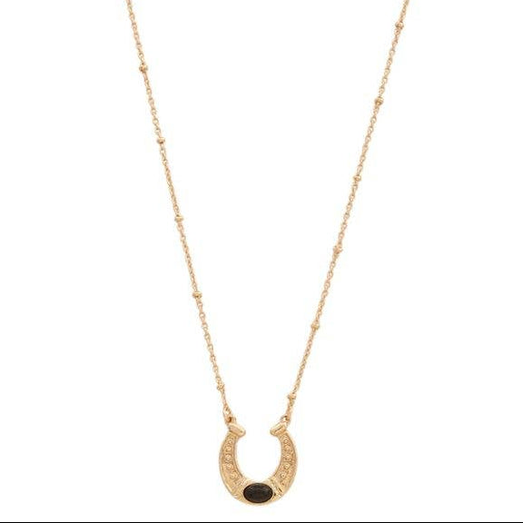 Gold necklace with a horseshoe black stone pendant on a white background
