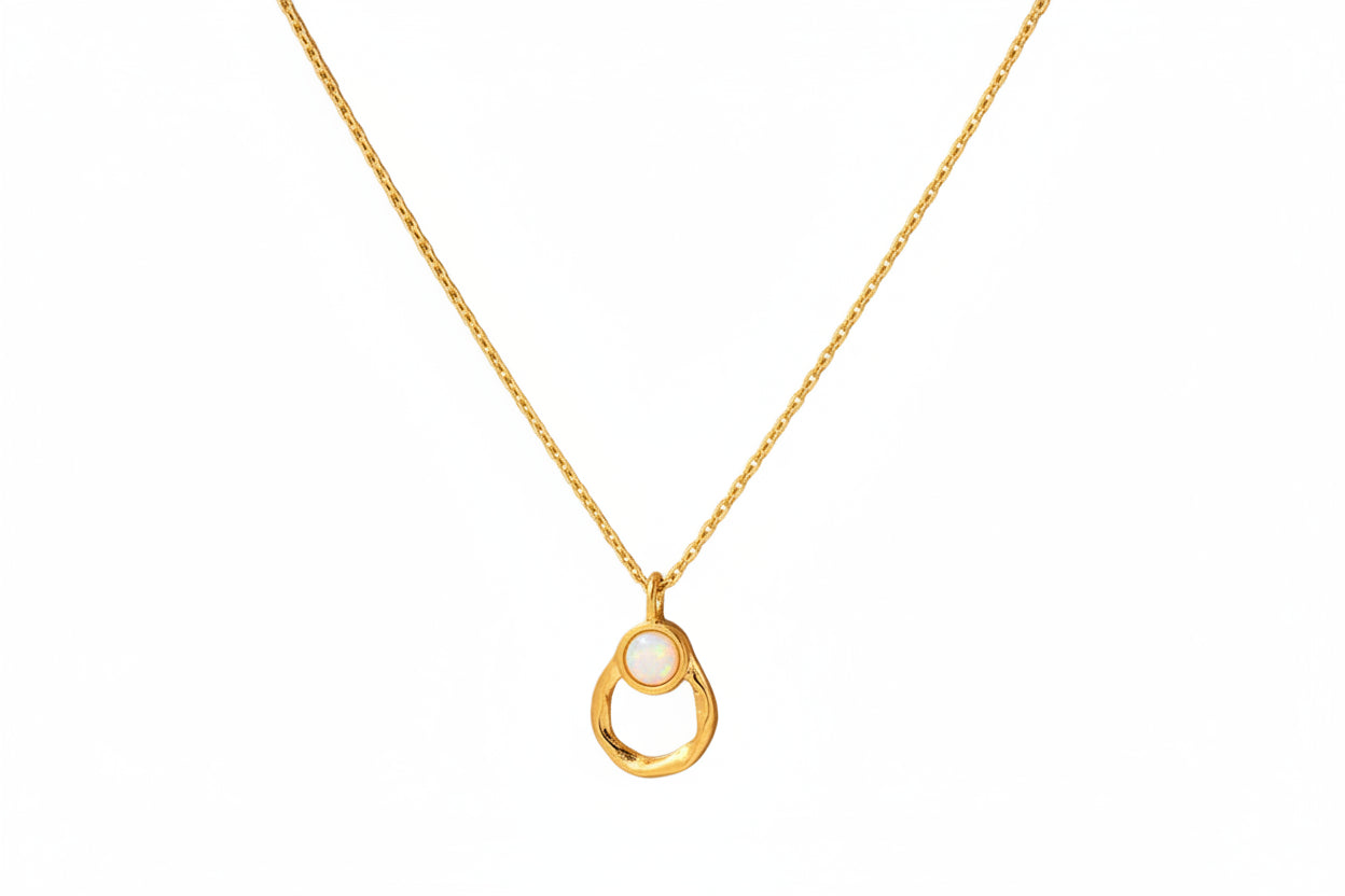 Gold necklace with a pendant on a brown card with text