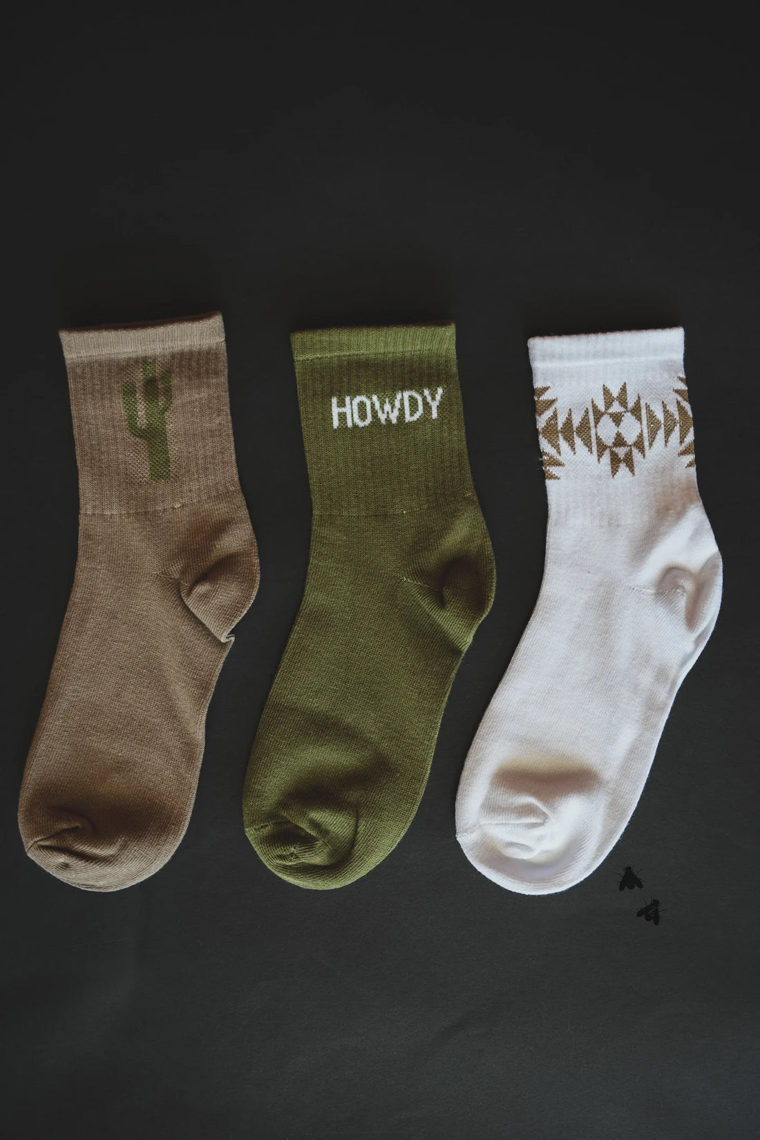 Sock Em Silly Cacti Mood Socks Set featuring three unique designs: a cactus silhouette, &quot;Howdy&quot; text, and a geometric Western pattern. One size fits most.