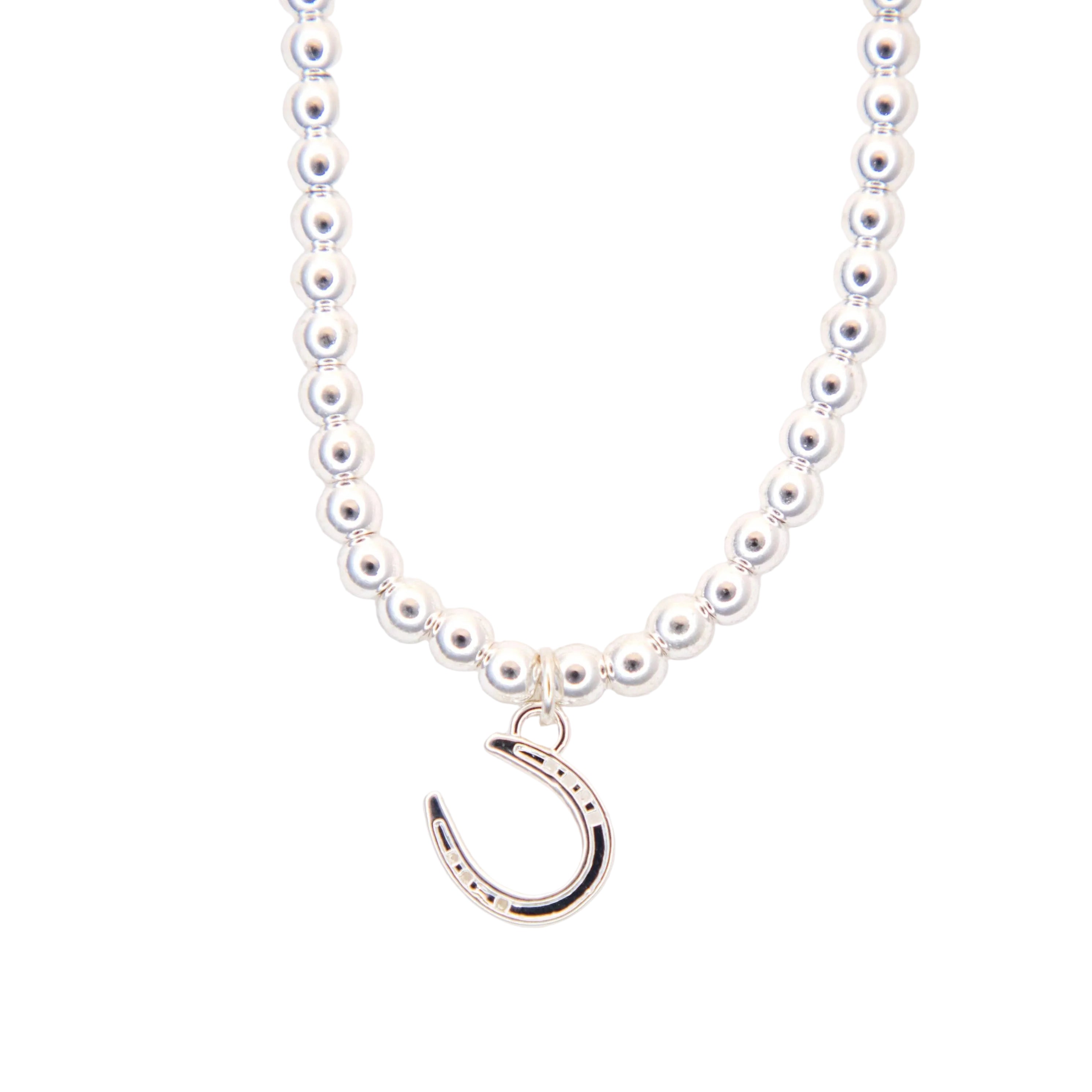 silver necklace with a silver horseshoe pendant on a white background
