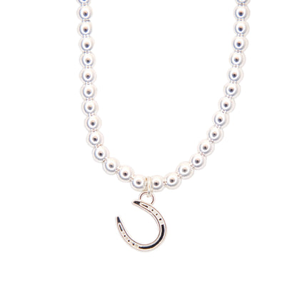 silver necklace with a silver horseshoe pendant on a white background