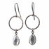 Silver hoop earrings with teardrop-shaped clear stones on a white background
