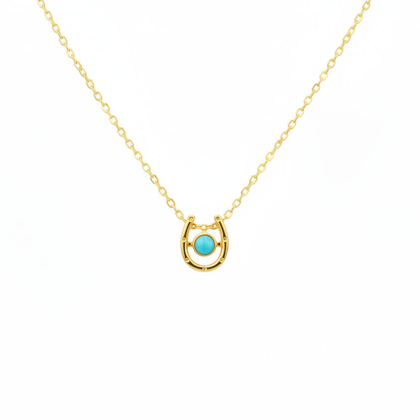 Gold necklace with a horseshoe pendant and turquoise stone 