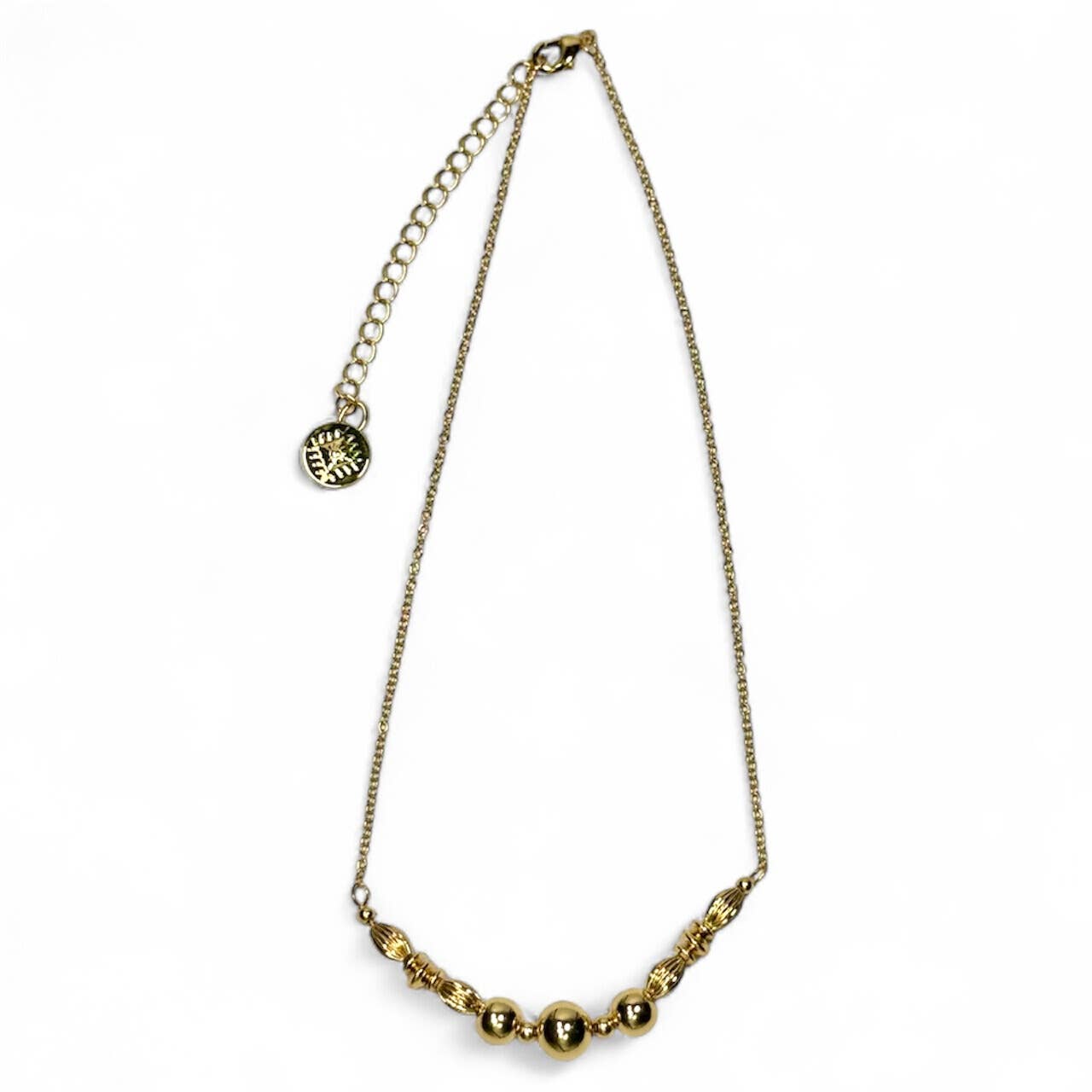 Gold necklace with spherical beads on a white background