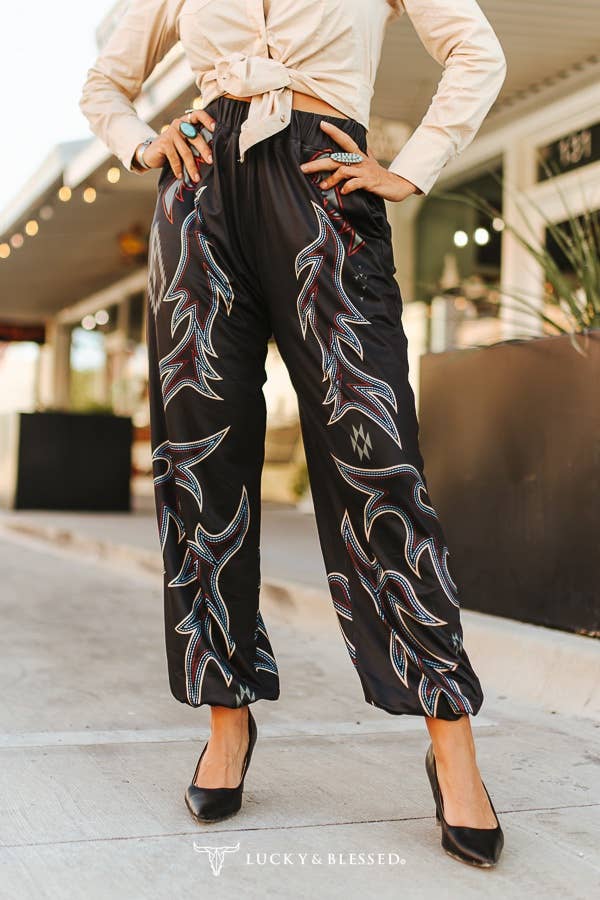 Person wearing black pants with white patterns in an outdoor setting