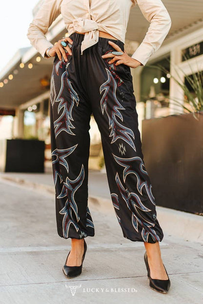 Person wearing black pants with white patterns in an outdoor setting