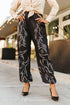 Person wearing black pants with white patterns in an outdoor setting