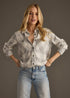Woman wearing a plaid shirt and jeans against a plain background