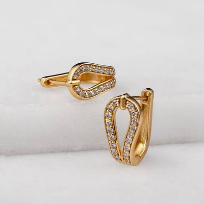 Gold hoop earrings with embedded stones on a light gray background