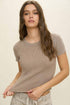 Woman wearing a ribbed brown t-shirt against a plain background