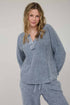 Woman wearing a blue pajama set against a plain background