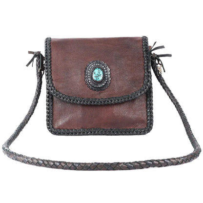 Brown leather handbag with braided strap on a white background