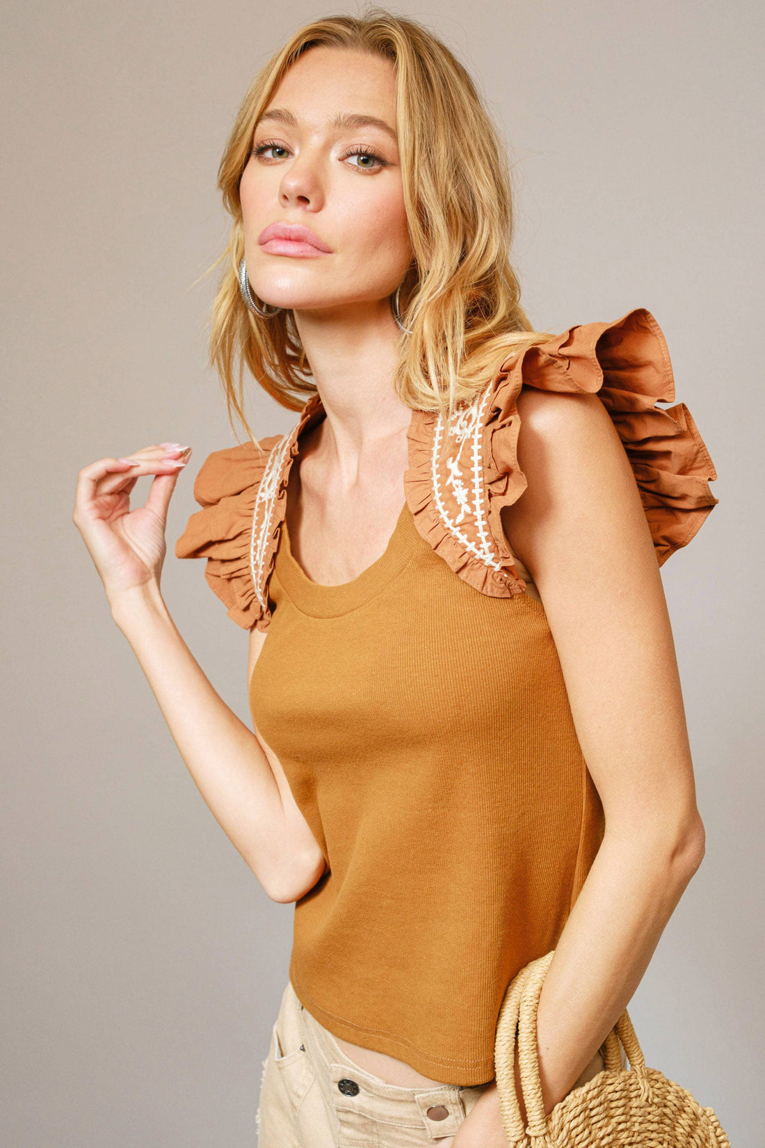 Fitted tank top featuring floral embroidered ruffle shoulders, crafted from a soft and stretchy cotton blend. Versatile for layering or wearing on its own.