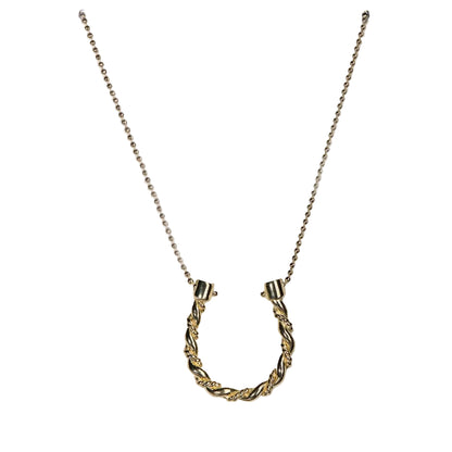 Gold necklace with a horse shoe pendant on a white background
