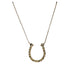 Gold necklace with a horse shoe pendant on a white background